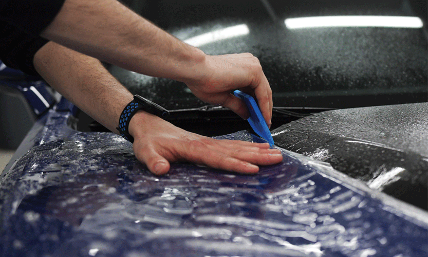 Davien from Prestige Auto Appearance meticulously installing PPF (Paint Protection Film) on a Camaro at our Automobile Aesthetic and Detailing Studio in Lehigh Valley, Allentown. Expert PPF installation for superior paint protection.